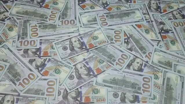 One hundred dollars are scattered on the table. American bills. A lot of money fills the simple people in the picture.