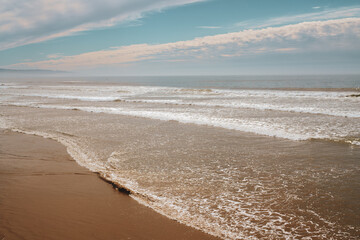 Wide sandy beach and ocean view at sunsetwith beautiful cloudy sky on bakground, Pismo Beach, California