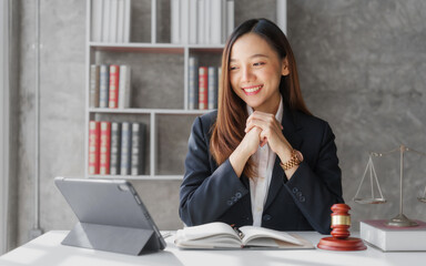 Attractive young female asia lawyer working with contract papers and online consulting with the new law of real estate business.  Law, legal services, advice, Justice, legislation