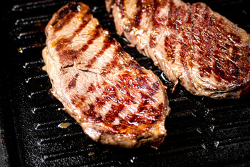 Aromatic grilled steak in a frying pan. 