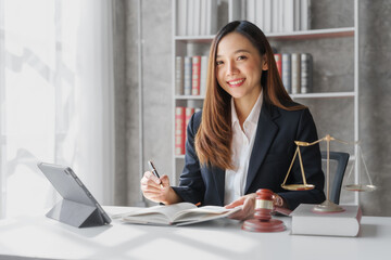 Attractive young female asia lawyer working with contract papers and online consulting with the new...