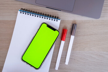 Mobile phone chroma key display. Laptop technology. High quality top view photo with smartphone. Online banking, application, empty space for logo, emblem. Mock up.