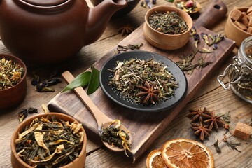 Different dry aromatic teas on wooden table