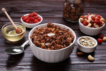 Tasty granola served with nuts, different ingredients on wooden table