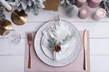 Festive place setting with beautiful dishware, cutlery and cone for Christmas dinner on white...
