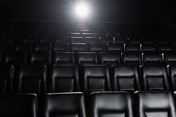 Fototapeta premium An empty cinema hall. Black stylish hall. Light from the projector