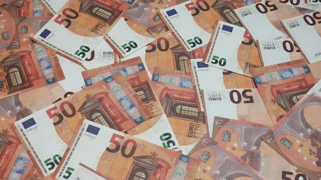 There are fifty euros on the table. A lot of money fills the common people in the picture. European currency with a denomination of 50 euros.