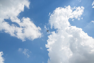 Naklejka na ściany i meble 맑은 하늘과 구름 사이로 비행하는 비행기