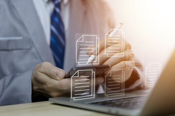 Businessman managing electronic documents on the laptop.	
