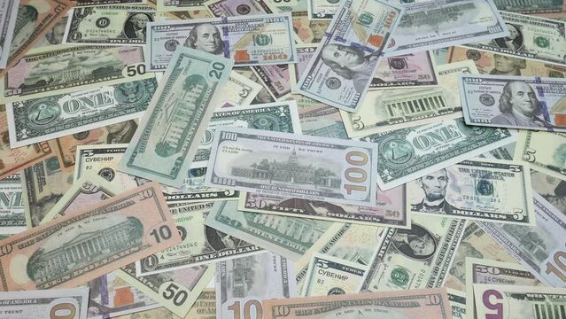 A hundred dollars, ten dollars, fifty dollars, one dollar are scattered on the table. American bills. A lot of money fills the simple people in the picture.