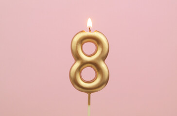 Birthday candle burning on pink background, number 8