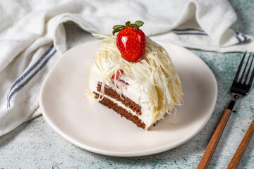 Layered white chocolate cake on a stone background. A slice of delicious strawberry cake. close up