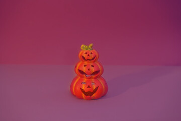 Cheerful fairy-tale figures made of clay and paper. Friendly pumpkins for Halloween. DIY with your own hands. Home decor. Violet background. Selective focus