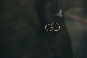 wedding rings on a table on a dark background