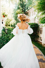 Fototapeta premium rear view. the bride walks through the garden. 