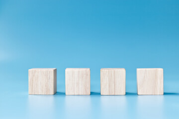 Four blank wooden blocks on blue background