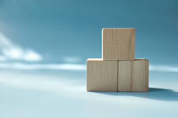 three stacked Blank wooden square cube on blue background