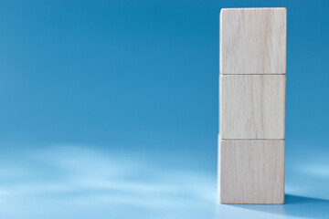 three stacked Blank wooden square cube on blue background
