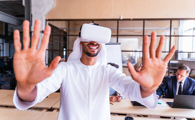 Multiethnic business team meeting in the office, portrait of arab businessman wearing emirates kandora and using vr technology at work