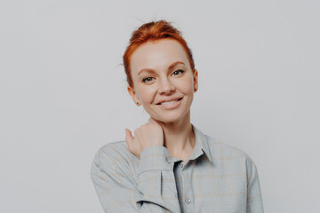 Obraz premium Young attractive smiling female with ginger hair in casual outfit isolated on grey studio background