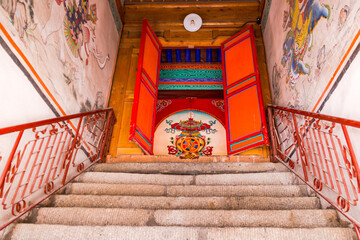 Stairs with railing leading to a painted door of a Tibetan temple at Kumbum Monastery, Xining, China