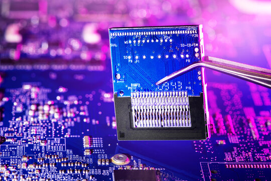 Electronic chip with tweezers. Production chip of  computer or repair pc system. Selective focus.