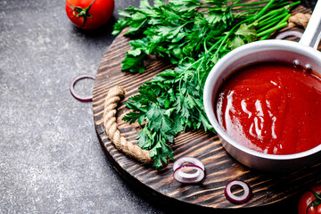 Tomato sauce with parsley and onion rings on the tray. 