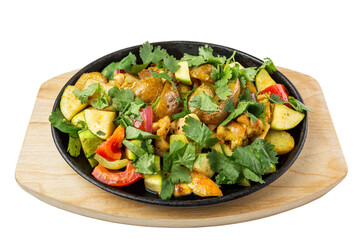 Fried potatoes with vegetables in a cast iron frying pan. Traditional popular dish. Top view. Close-up. Isolated on white background.