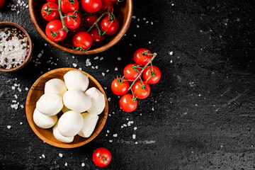Mozzarella cheese with tomatoes and spices in bowls on the table.
