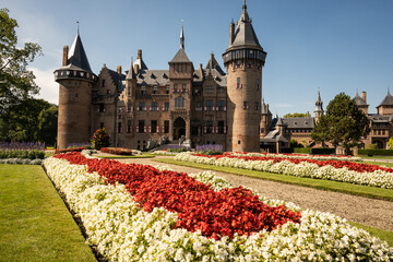 outside of Kasteel De Haar Dutch medieval castle with floral garden on sunny summer day. Flowers...