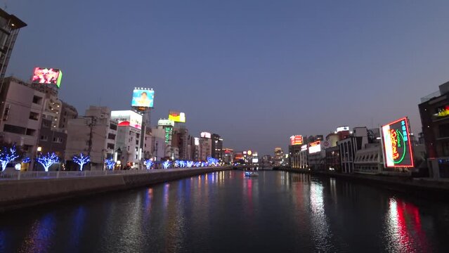 HAKATA, FUKUOKA, JAPAN - NOVEMBER 2022 : Time lapse shot of NAKASU area in sunset. Red-light district which exists between the sandbank of the Naka River and the Hakata River.