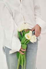 Part of the body of a girl who holds white tulips. Valentine concept. 