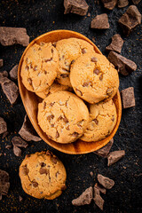 Wooden plate with cookies and pieces of milk chocolate. 