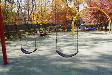 Almaty, Kazakhstan - 10.12.2022 : Children's play swing on the territory of the kindergarten