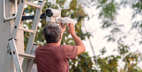 Technician worker installing video surveillance camera