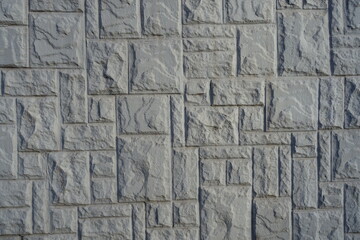 Texture of gray concrete brick veneer wall with random layout