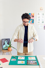 Focused man photographing charts in creative workspace