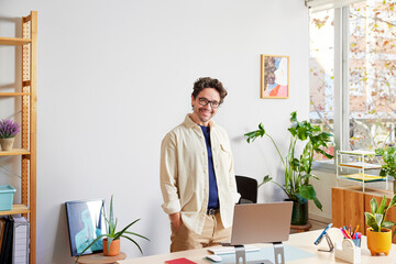 Happy man with netbook in workspace