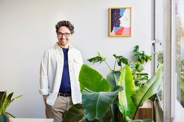 Smiling man standing near window in studio