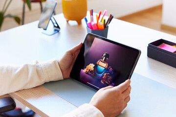 Crop man checking photos on tablet in workspace