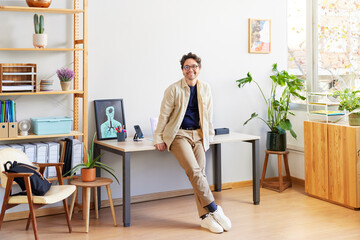 Smiling male designer standing in light creative studio