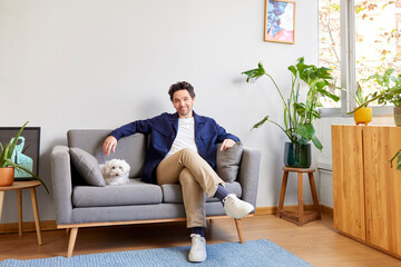 Man and dog resting on sofa