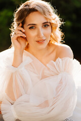 Naklejka premium portrait of a beautiful blonde bride in a white dress at sunset