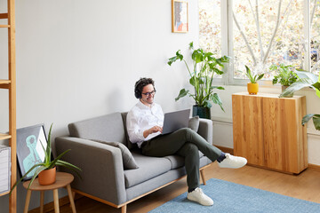 Male freelancer working remotely in living room