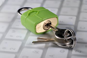 Green lock with keys on a computer keyboard, close-up, cyber security concept - obrazy, fototapety, plakaty