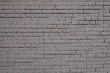 Texture of grayish pink painted brick veneer wall