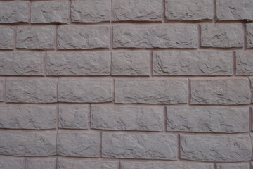 Obraz premium Textured surface of grayish pink painted brick veneer wall