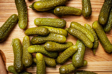 Pickled cucumbers on a wooden background.