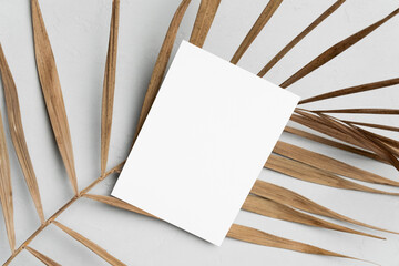Blank greeting card, flyer or invitation mockup with natural palm leaf