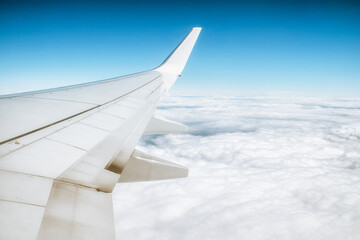 Obraz premium View from window of airplane on wing and blue sky with white clouds